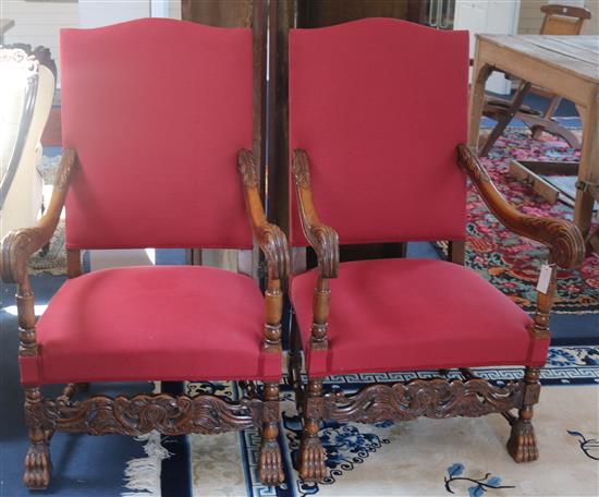 A pair of Carolean style carved beech open armchairs